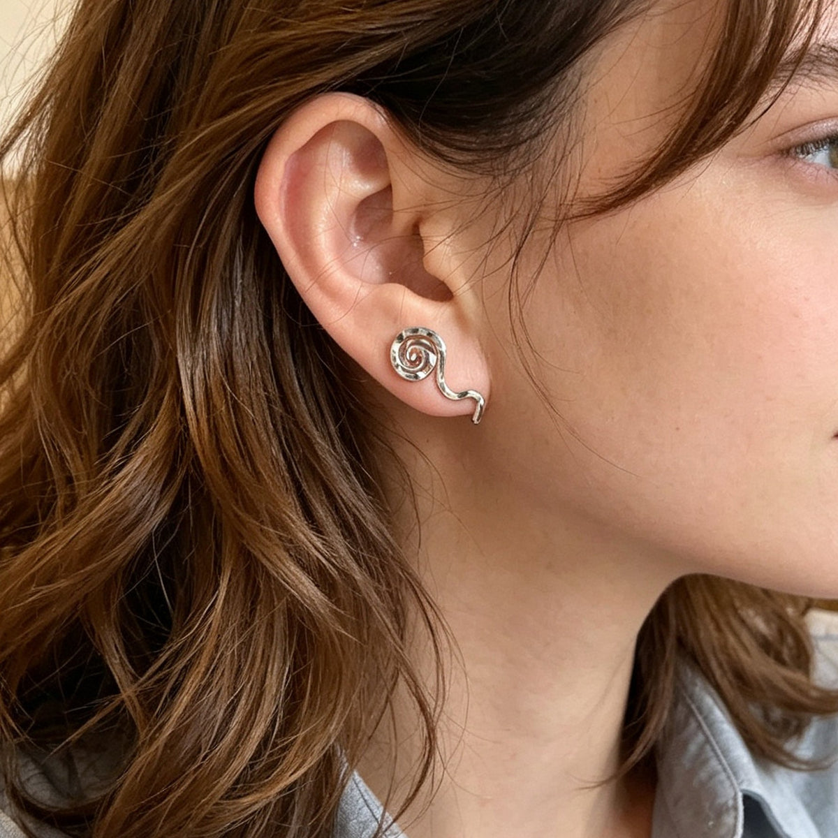 Silver spiral ear cuff with curved clip, no-piercing on model's ear