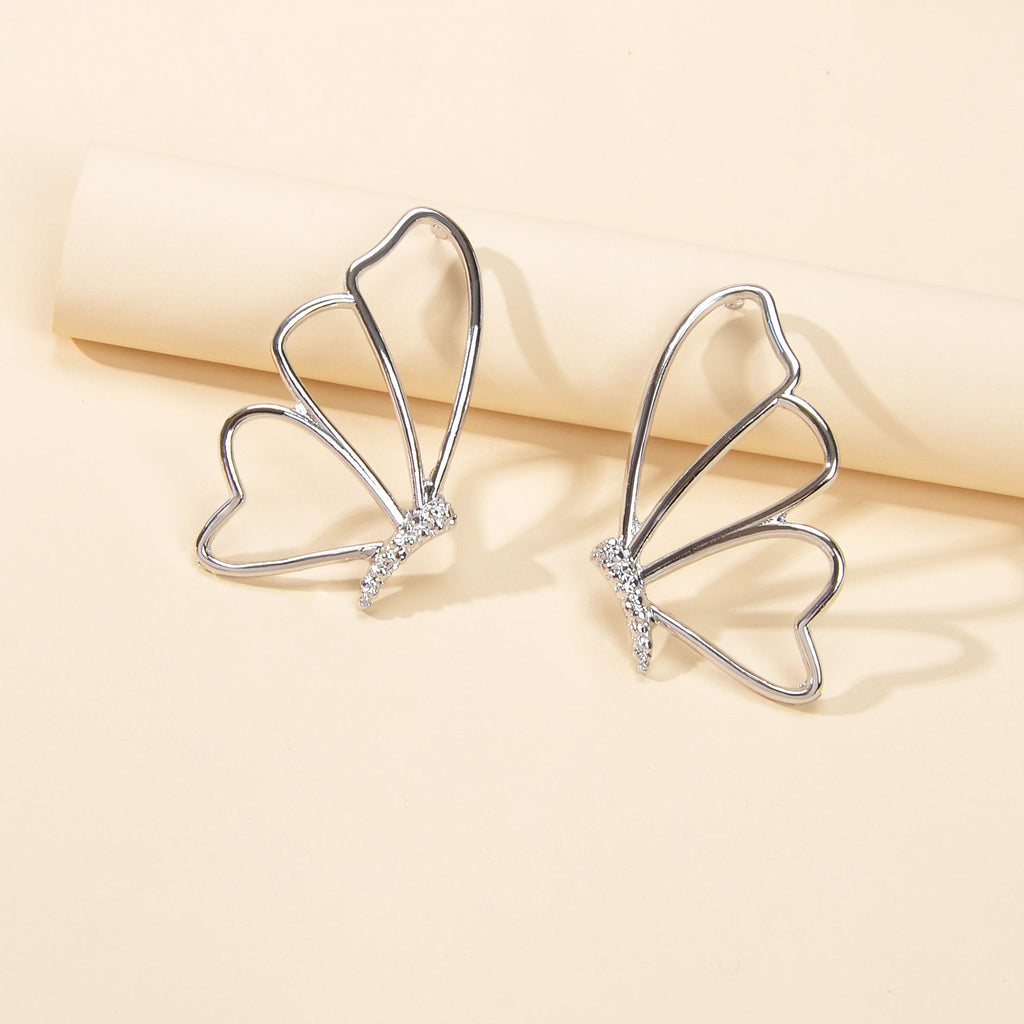 Silver hollow butterfly stud earrings with four wing arcs and rhinestone accents