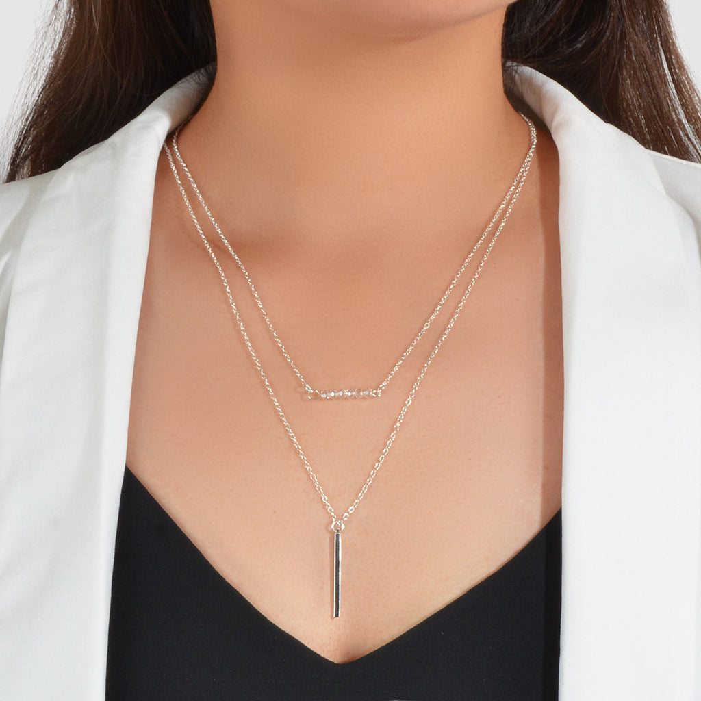 Gold-tone double-layer chain necklace with small bead accents and vertical bar charm