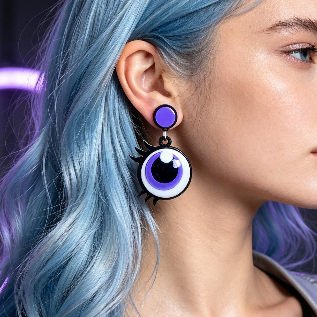 Purple cartoon eye dangle earrings worn, with black crescent and white eye highlight