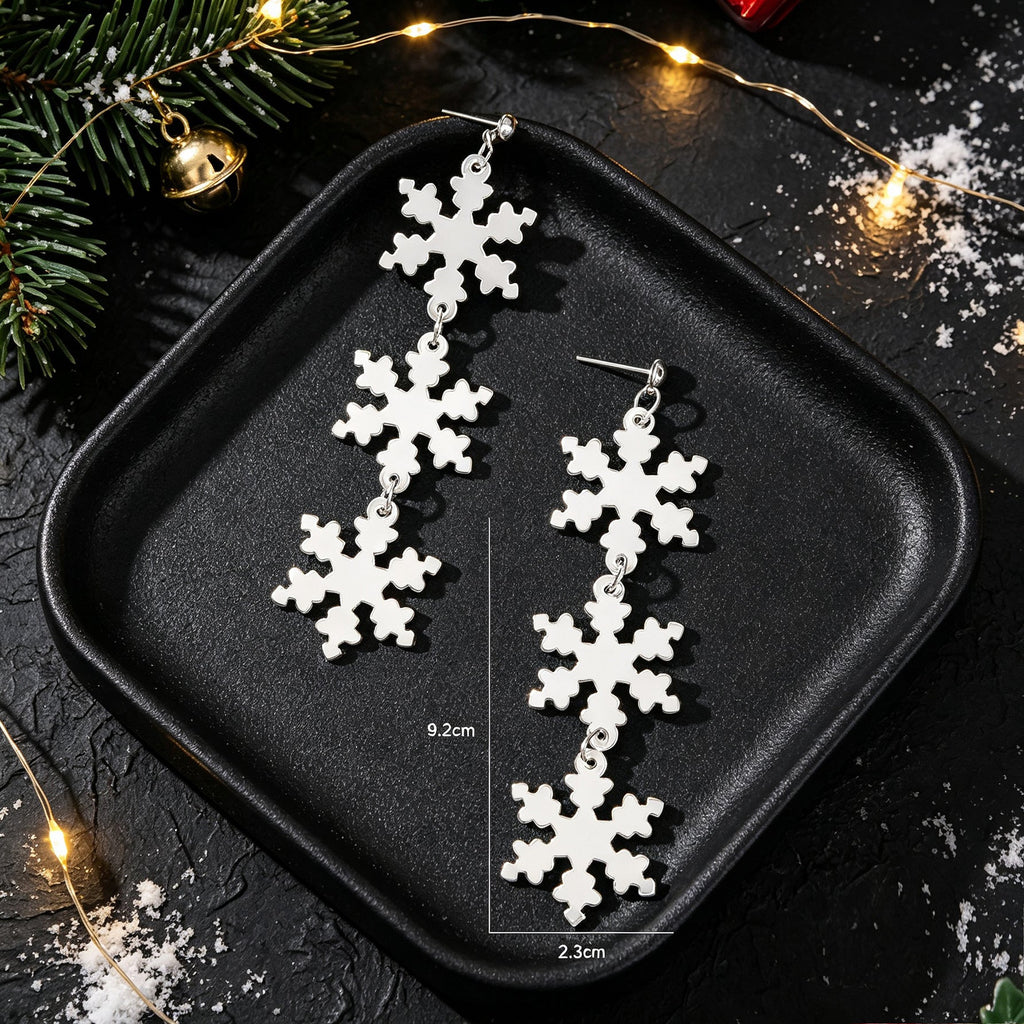 Silver snowflake long dangle earrings with measurement guide on black tray