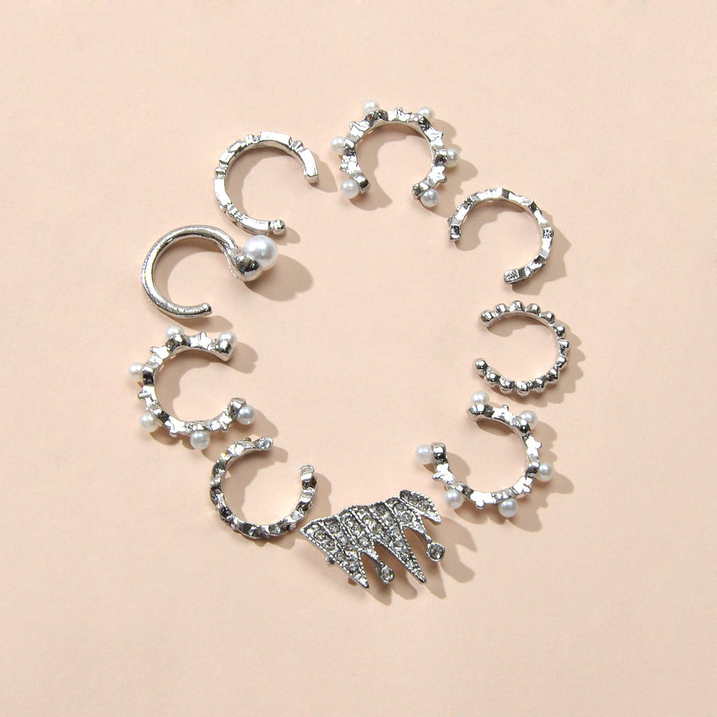 Silver ear cuff set with rhinestones, pearl-like beads, and one spiky charm