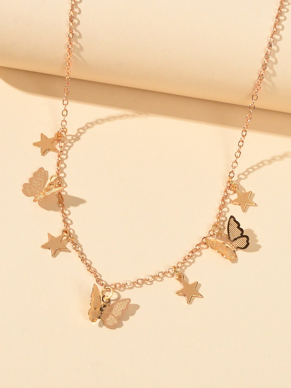 Gold chain collar necklace with star and butterfly charms, short neckline fit