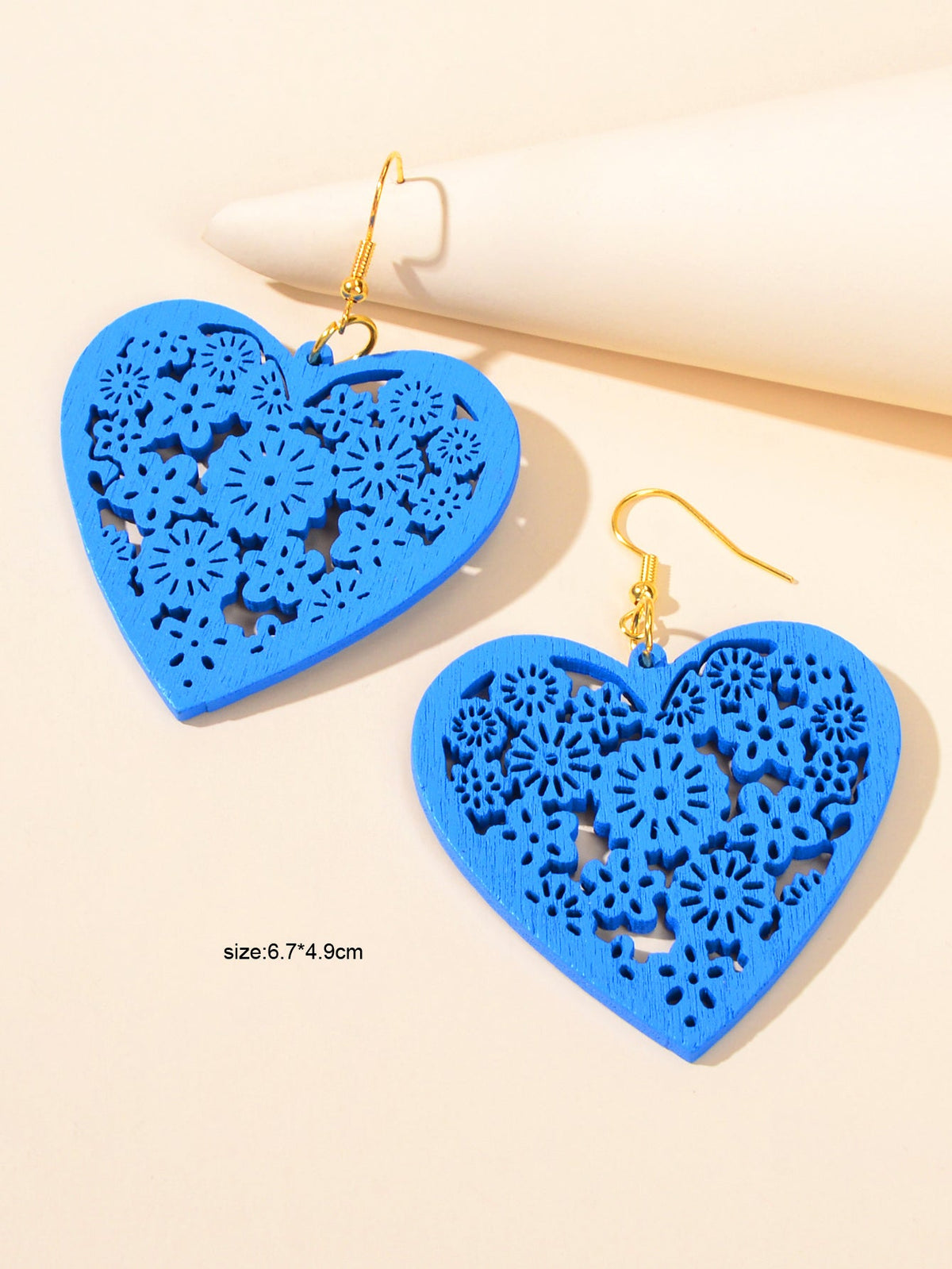 Blue heart dangle earrings with hollow floral cutout pattern and gold hooks