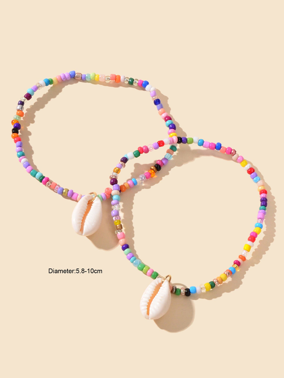 Two multicolor beaded ankle bracelets with white cowrie shell charms