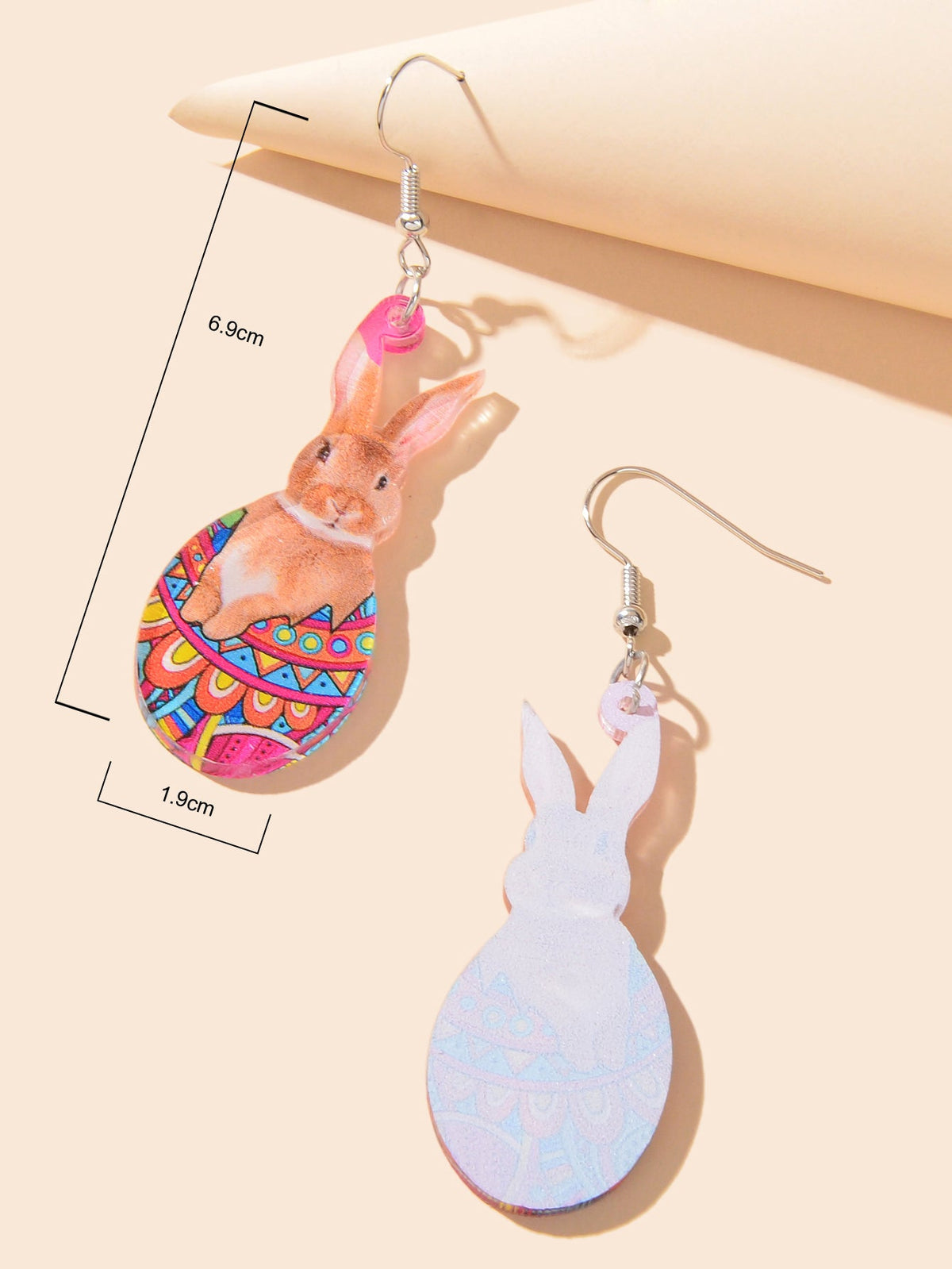 Dangling bunny charm earrings; brown patterned and white bunny variants shown with size marks
