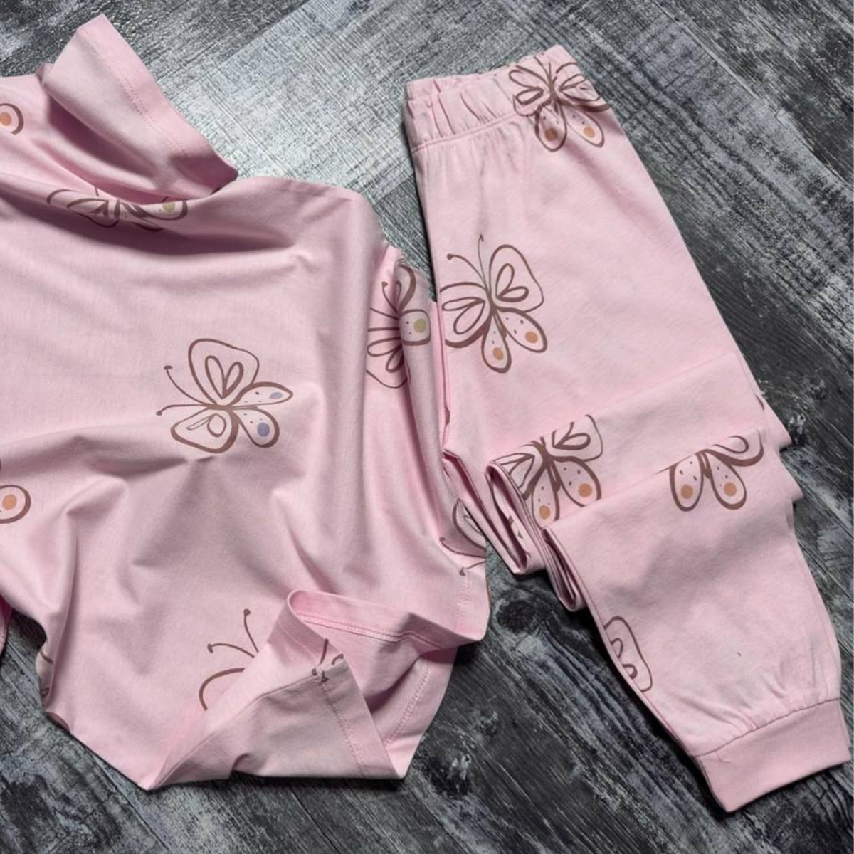 Girls' pink butterfly-print pajama set with matching pants shown flat