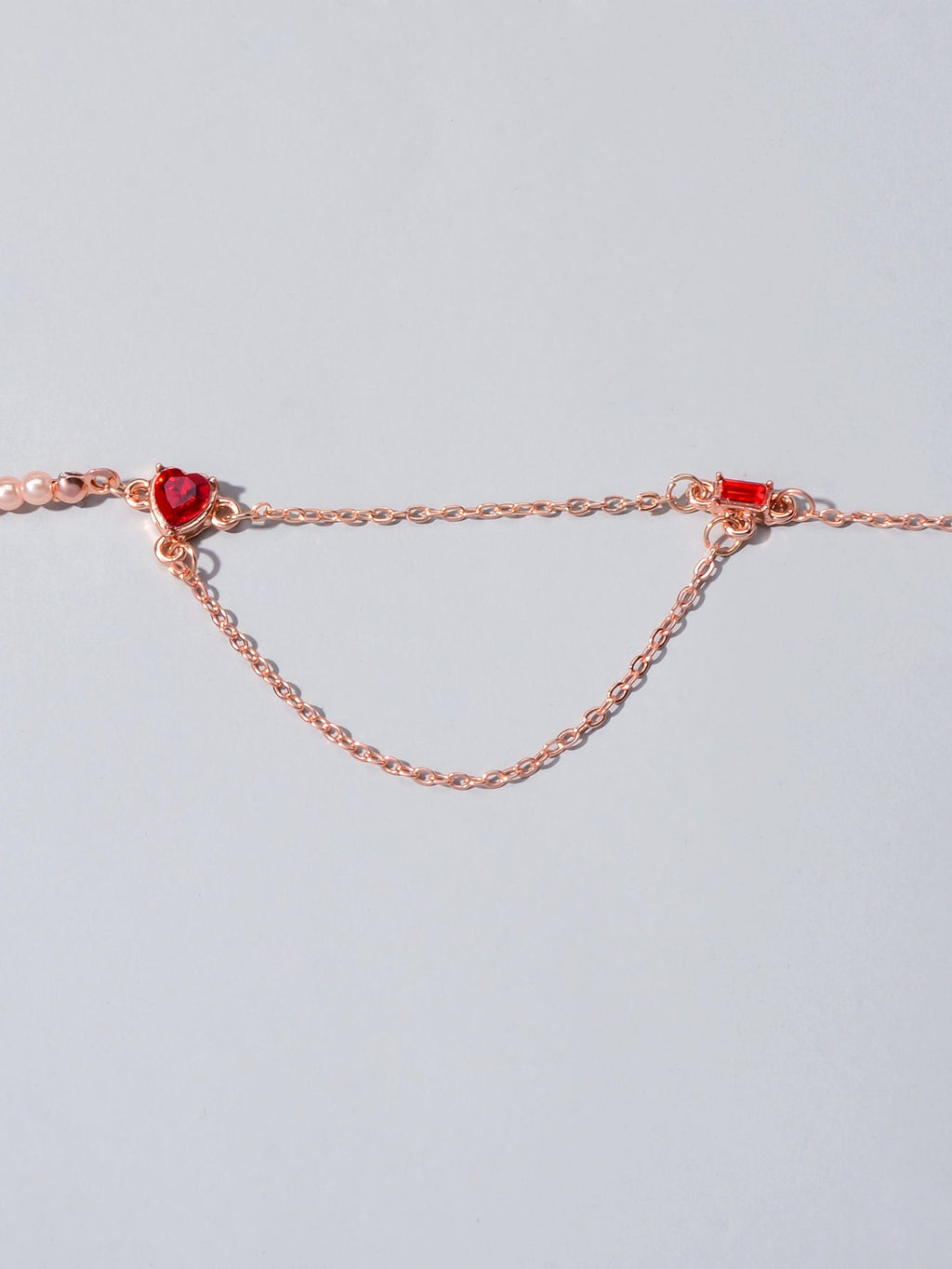 Rose gold tone chain necklace with red crystal heart and small red stones