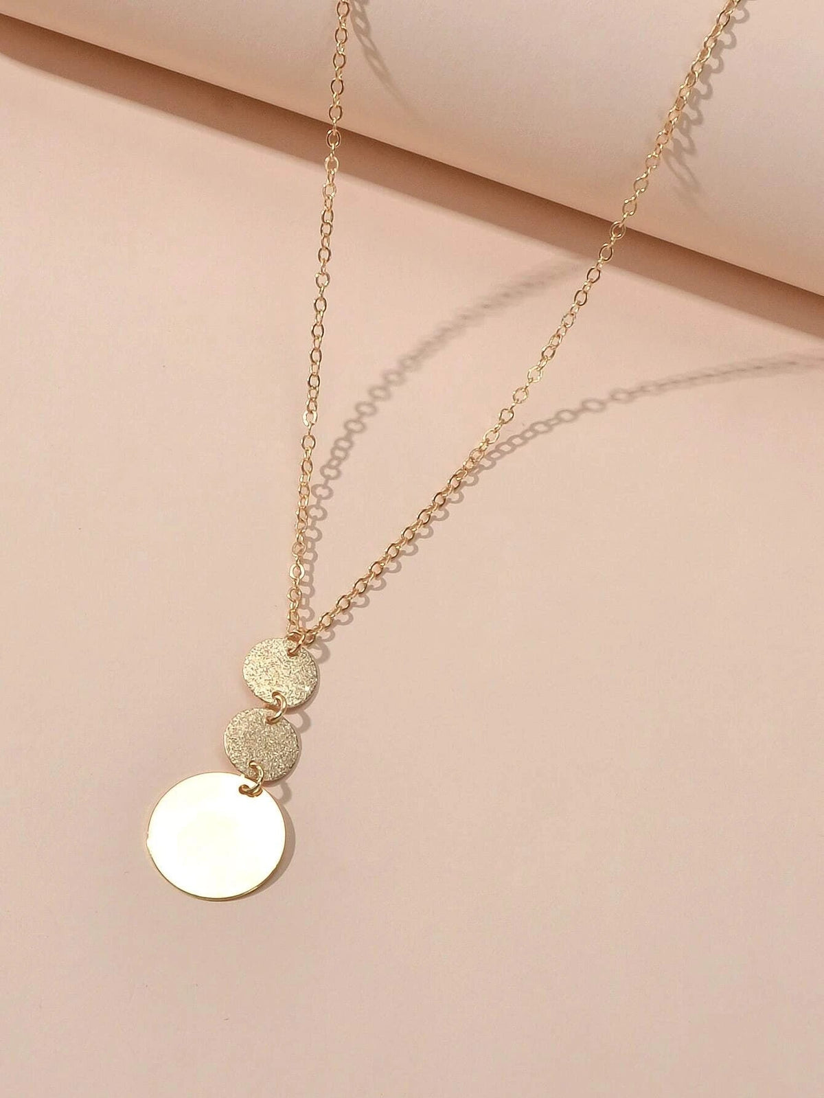 Gold-tone layered necklace with round disc and heart pendants