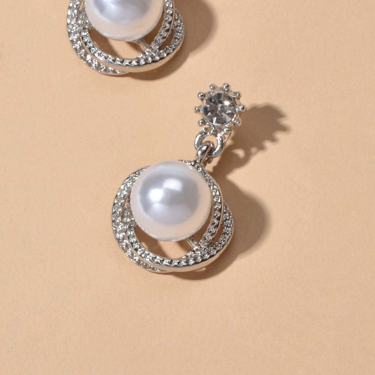 Silver-tone pearl drop earring with rhinestone spiral halo and round pearl