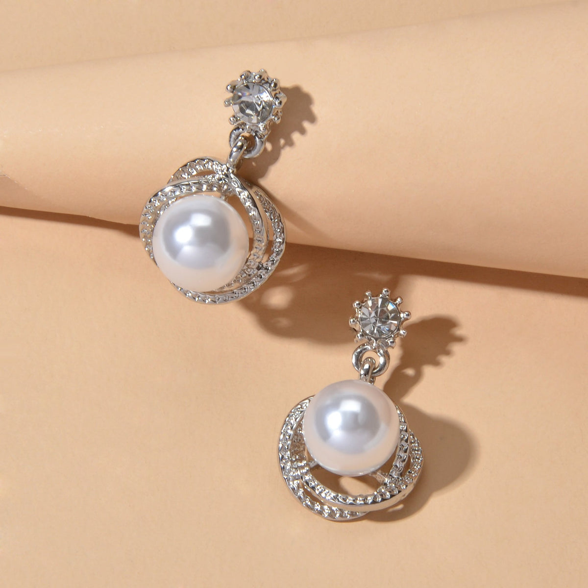 Silver-tone round pearl drop earrings with rhinestone halo and flower-like stud