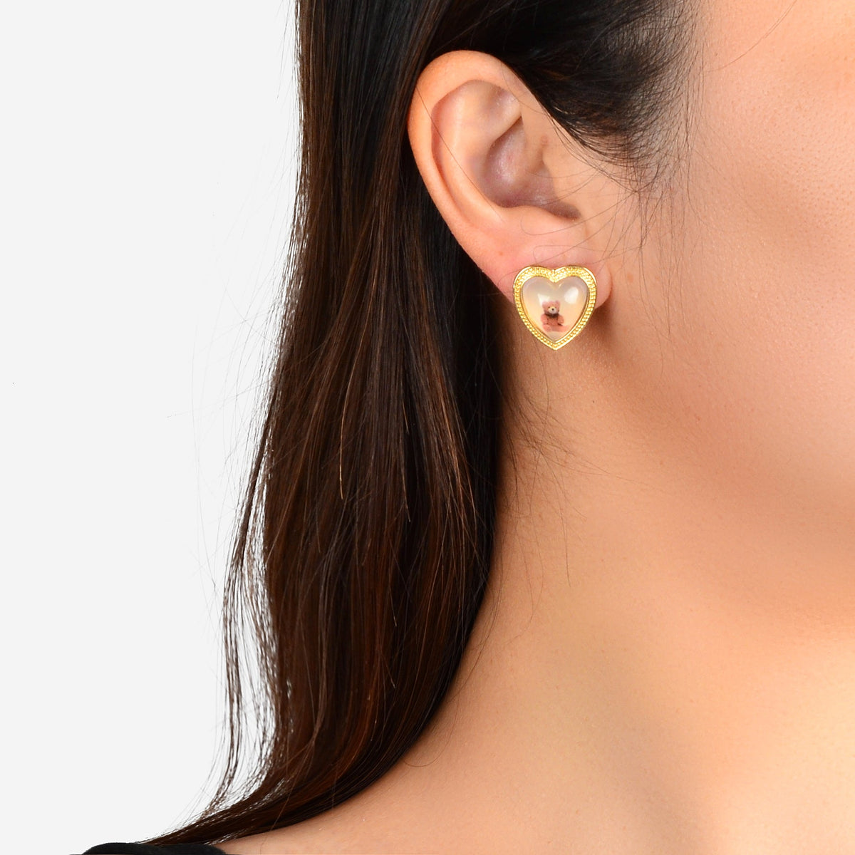 Heart resin stud earrings with pink bear motif on pierced ear