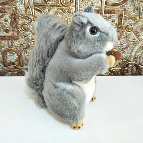 Grey squirrel plush toy with big ears and round black eyes, holding a small nut
