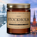 Amber glass candle jar with gold ribbed lid, flame lit
