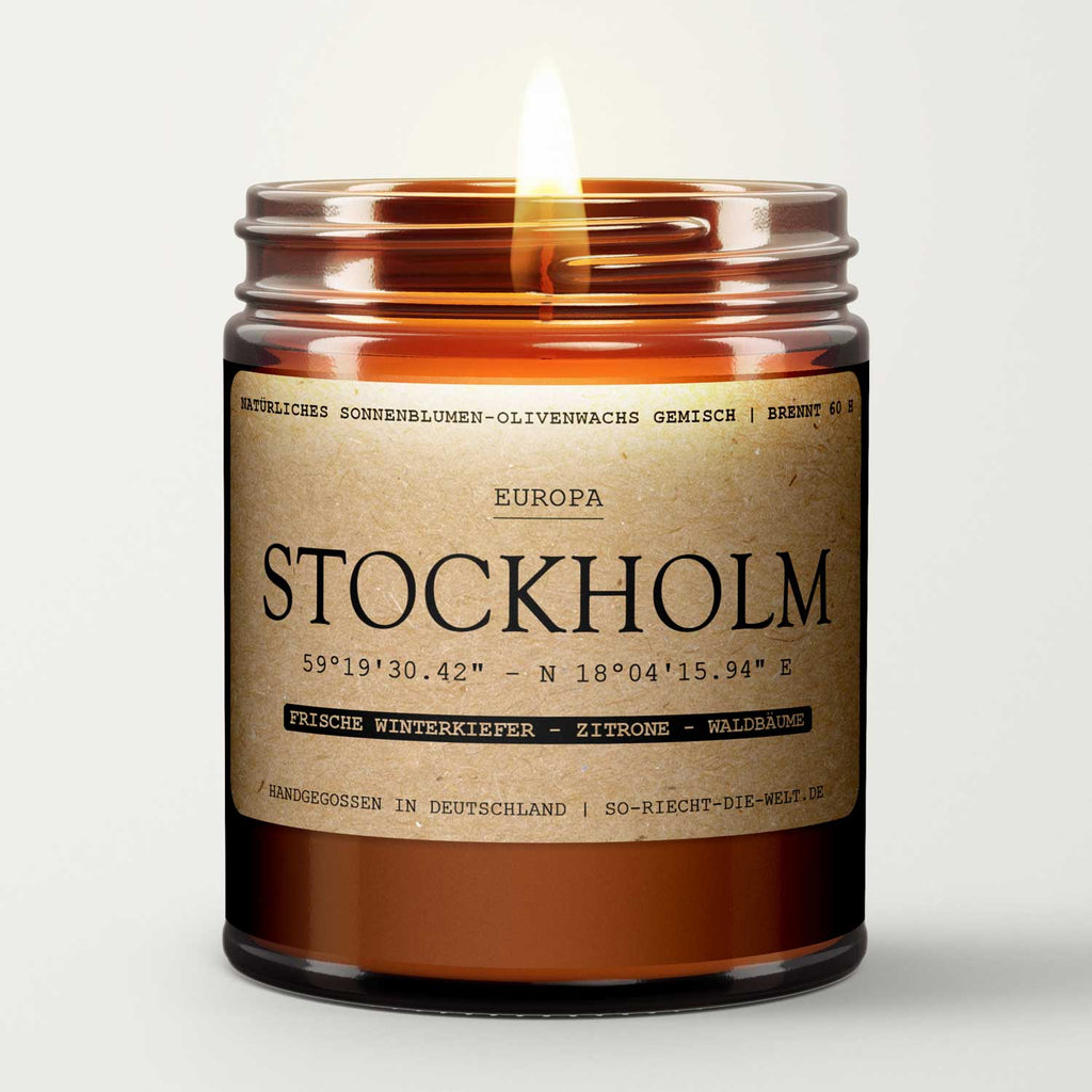 Amber glass candle jar with open gold lid, flame centered