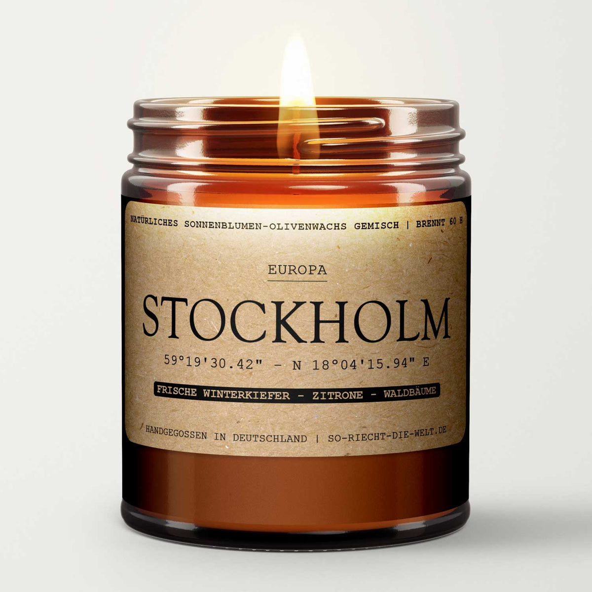 Amber glass candle jar with open gold lid, flame centered