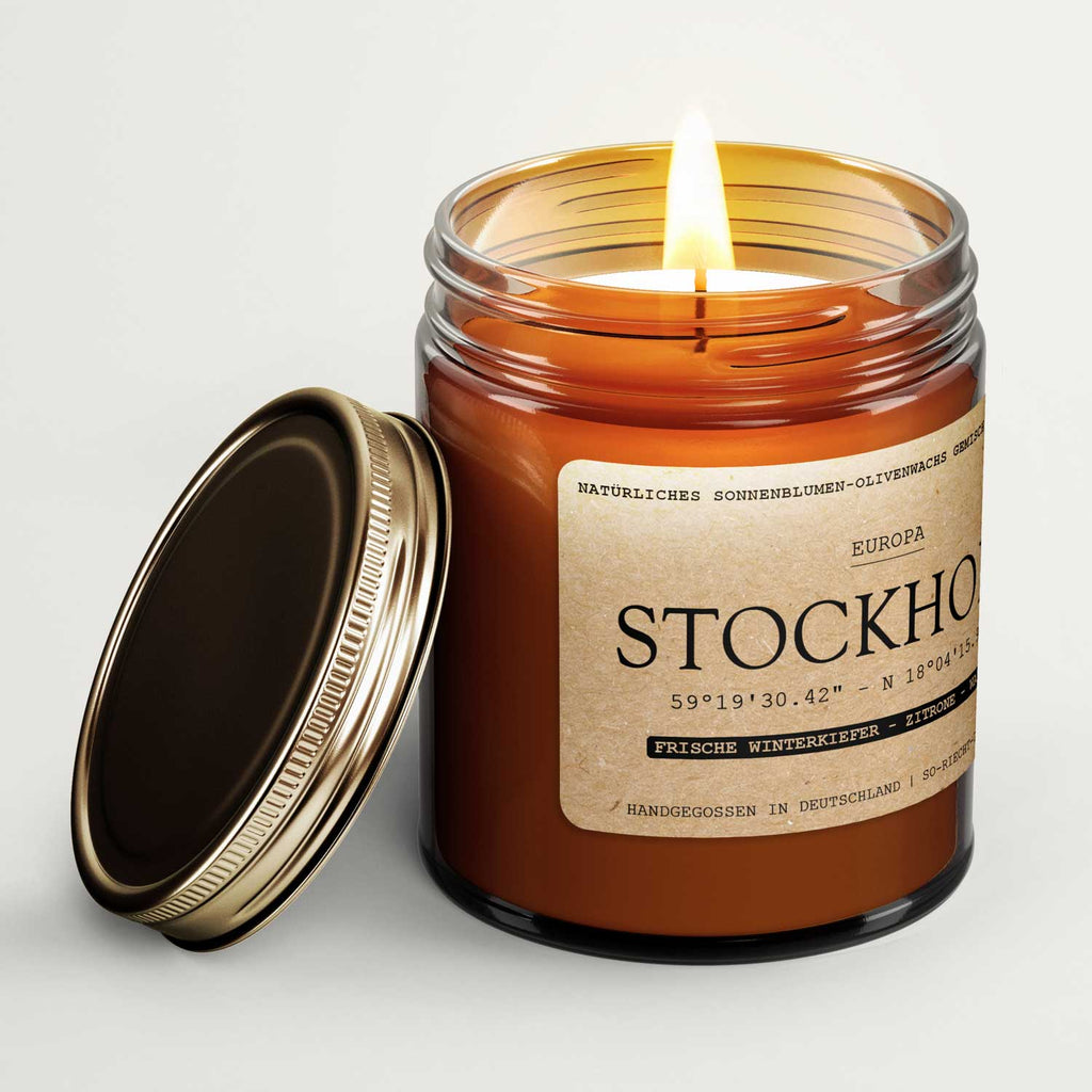 Amber candle jar with gold lid placed beside it, flame rising