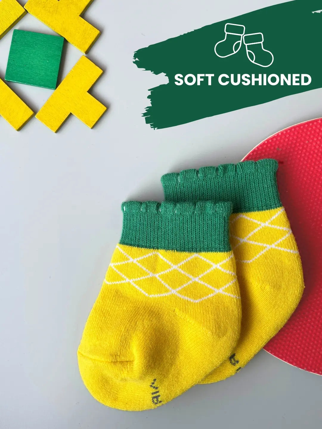Air Garb brand baby combo socks for infants; a 6-pair set of soft cotton socks featuring pineapple, watermelon, cherry, and cute character face designs in vibrant colors like yellow, red, and blue.
